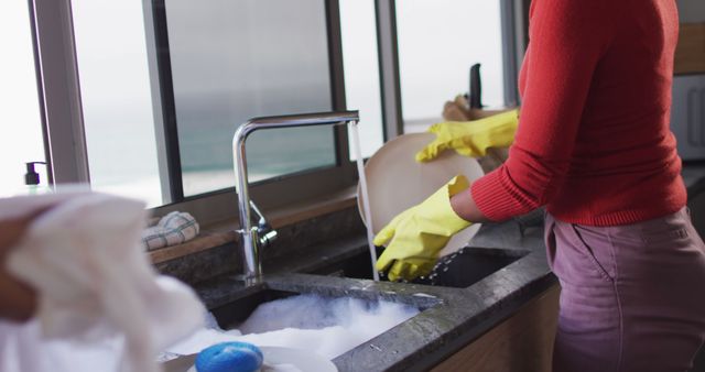 Person Washing Dishes with Yellow Gloves in Kitchen Next to Window - Download Free Stock Images Pikwizard.com