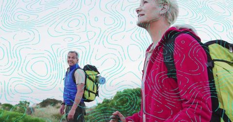 Couple trekking coastal trail with backpacks and trekking pole