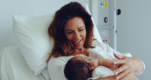 Mother Holding Newborn Baby in Hospital Bed, Smiling with Love - Download Free Stock Images Pikwizard.com