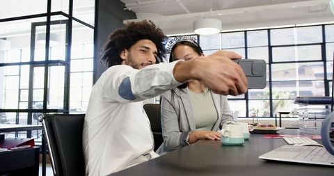 Diverse professionals celebrating office party with selfie