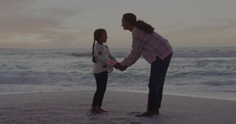 Mother and Daughter Holding Hands in Sunset Seaside Serenity