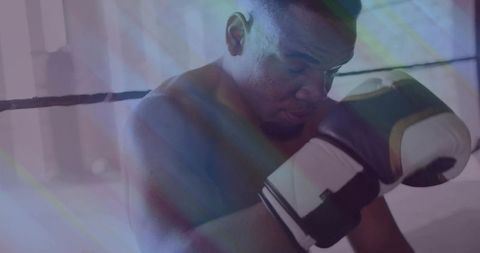 Boxer leaning in ring corner preparing for next round holding gloves to face