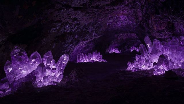 Glowing amethyst crystal cavern illuminating dark underground passage with violet glow