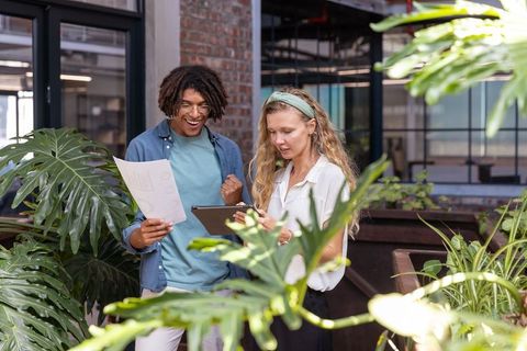 Diverse Professionals Discussing Data in Modern Green Workspace