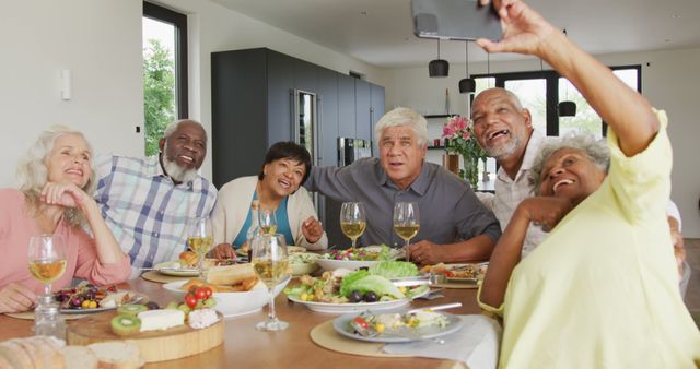 Happy senior diverse people having dinner and taking selfie at retirement home - Download Free Stock Photos Pikwizard.com