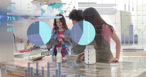 Young women collaborating on baking with tablet and data overlays in modern kitchen island