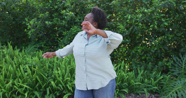 African american senior woman dancing in the garden. social distancing quarantine lockdown during coronavirus pandemic concept