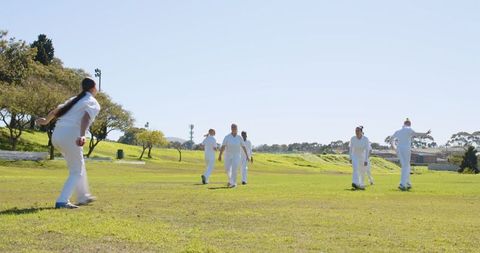 Diverse Female Cricketers Practicing Bowl in sunny Outdoor Field