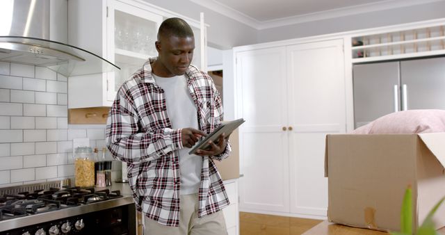 Young Man Using Digital Tablet in Modern Kitchen During House Move - Download Free Stock Images Pikwizard.com