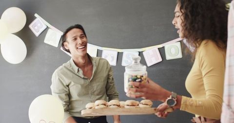 Colleagues preparing decor and food for office celebration