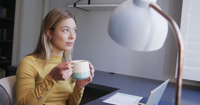 Young Woman Working from Home Holding Coffee Cup - Download Free Stock Images Pikwizard.com