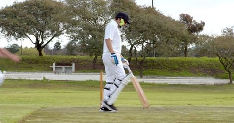 Cricketer Preparing Stance on Maintained Cricket Ground