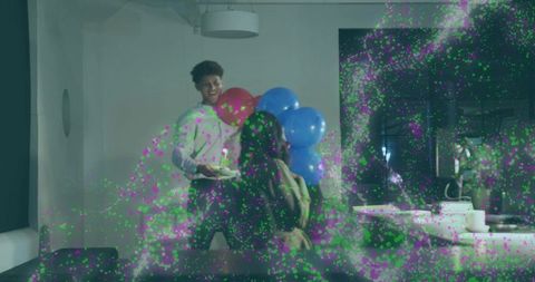 Man offering cake and blue balloons to partner for cozy living room surprise celebration