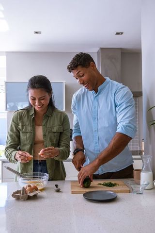 Diverse Couple Cooking Delicious Meal in Modern Kitchen
