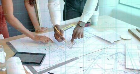 Architects Collaborating on Blueprints in Modern Design Studio