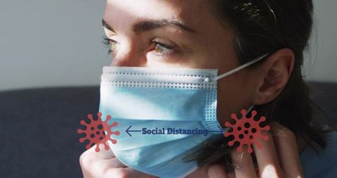 Woman adjusting surgical mask while practicing social distancing and ppe awareness at home