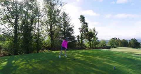 Senior Woman Engaging in Leisurely Golf Activity Amidst Lush Greenery