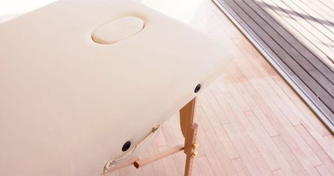 Massage table in sunlit room ready for relaxation session