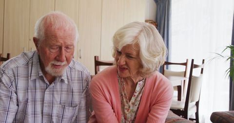 Senior couple sitting together reviewing paperwork