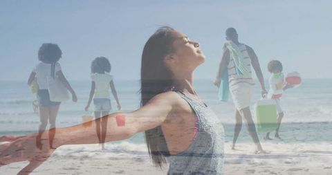 Woman Enjoying Freedom on Beach with Family in Background