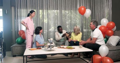 Diverse group celebrating new patient arrival in rehabilitation center