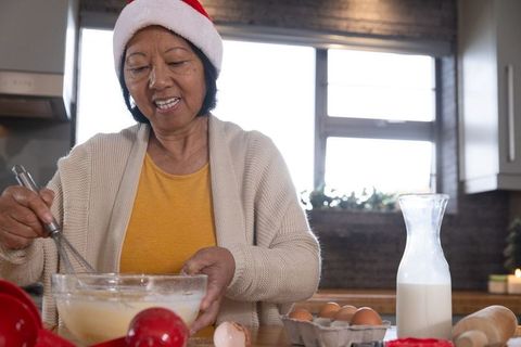 Senior Woman in Santa Hat Baking in Cozy Kitchen