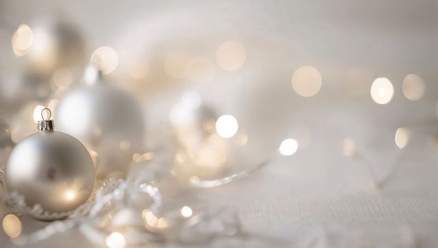 Minimalist Silver Christmas Baubles with Warm Fairy Light Bokeh and Copy Space