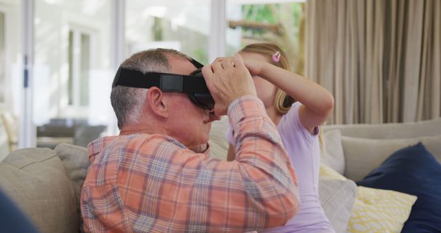 Grandfather Trying VR Headset Helped by Granddaughter in Living Room - Download Free Stock Images Pikwizard.com
