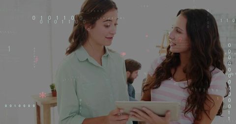 Two colleagues collaborating over tablet with digital binary overlay in modern office