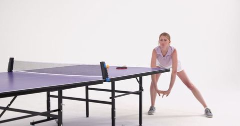 Female Ping Pong Player Preparing Serve in Minimalist Studio