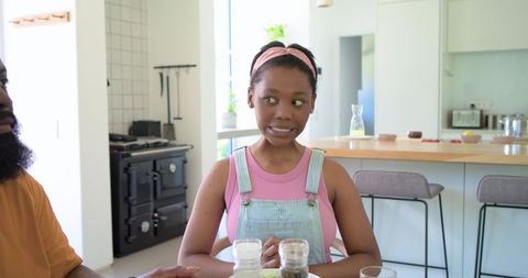 Awkward Teen Girl Sitting at Kitchen Island with African American Family During Mealtime