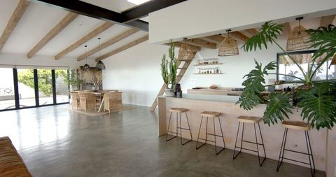 Modern Open-Concept Living with Wooden Beams and Bar Stools