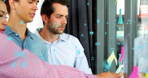 Diverse Team Analyzing Strategic Data on Glass Wall
