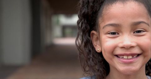 Joyful Young Girl Smiling Amidst Urban Walkway
