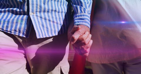 Senior Couple Holding Hands in Park with Light Effects