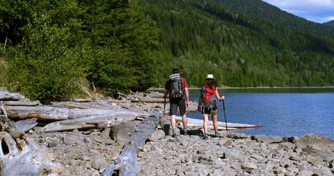 Couple Hiking Along Scenic Lakeside Trail Exploring Wilderness
