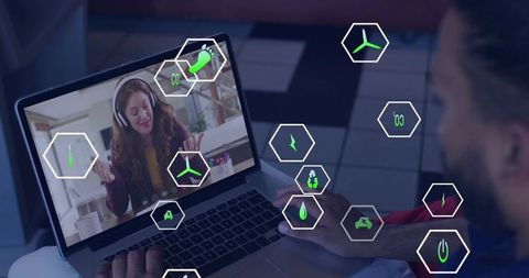 Man watching sustainability call while typing on laptop with virtual hexagon eco icons