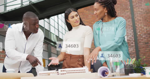 Diverse Team Discussing Blueprints with Social Media Overlay