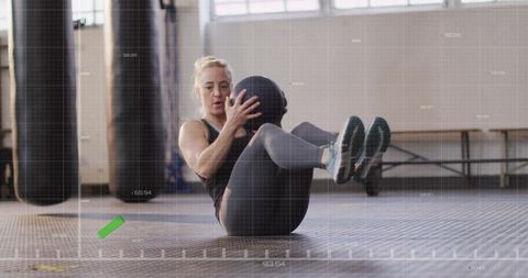 Active Middle-Aged Woman with Medicine Ball in Gym for Fitness Workout