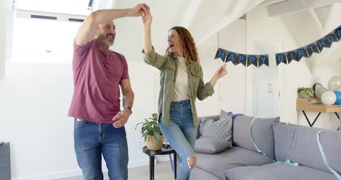 Joyful Mature Couple Dancing Together at Birthday Celebration