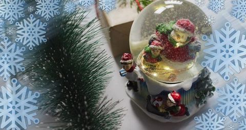 Glowing santa snow globe with pine branch and snowflake overlay for festive holiday design
