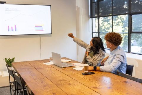 Diverse team analyzing charts and strategy during collaborative meeting in bright office