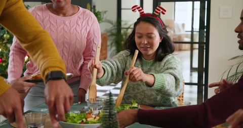 Friends Gathering Tossing Salad at Festive Holiday Dinner