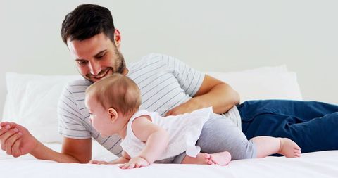 Father Spending Quality Time with Curious Baby Girl on Bed