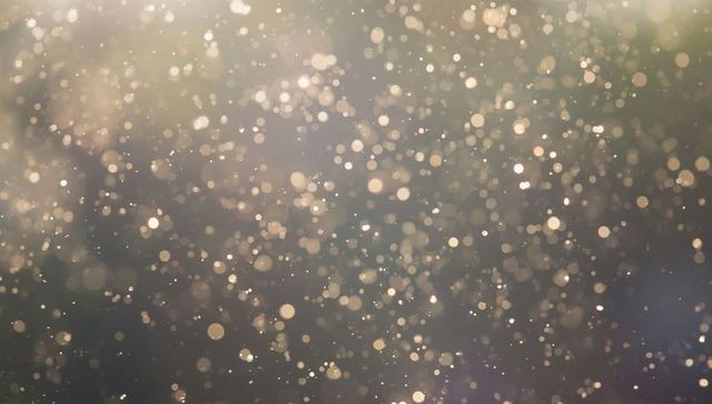 Dreamy bokeh orbs on neutral backdrop creating elegant glow