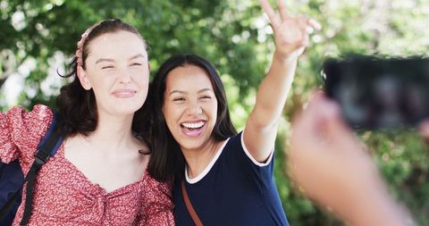 Cheerful friends posing outdoors for holiday snapshots