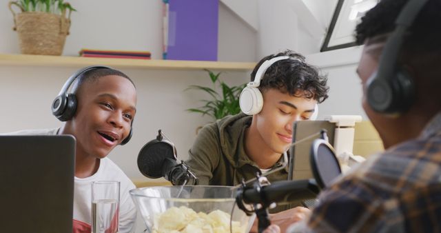 Group of teenagers recording a podcast in a modern studio. All are wearing headphones and speaking into microphones. This can be used to represent diverse discussions, modern technology in education, youth creativity, group projects in school, or social media content creation.