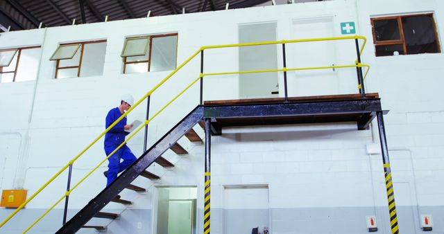 Engineer Walking Down Stairs in Modern Industrial Facility - Download Free Stock Images Pikwizard.com