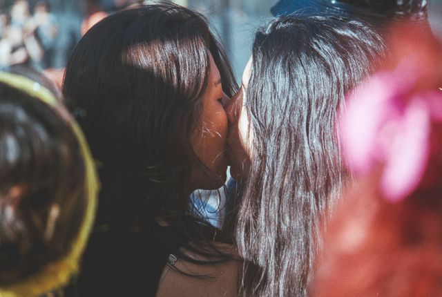 Two Women Kissing in Outdoor Festive Event - Download Free Stock Photos Pikwizard.com