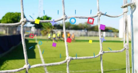 Soccer training focus seen through goal net with players practicing
